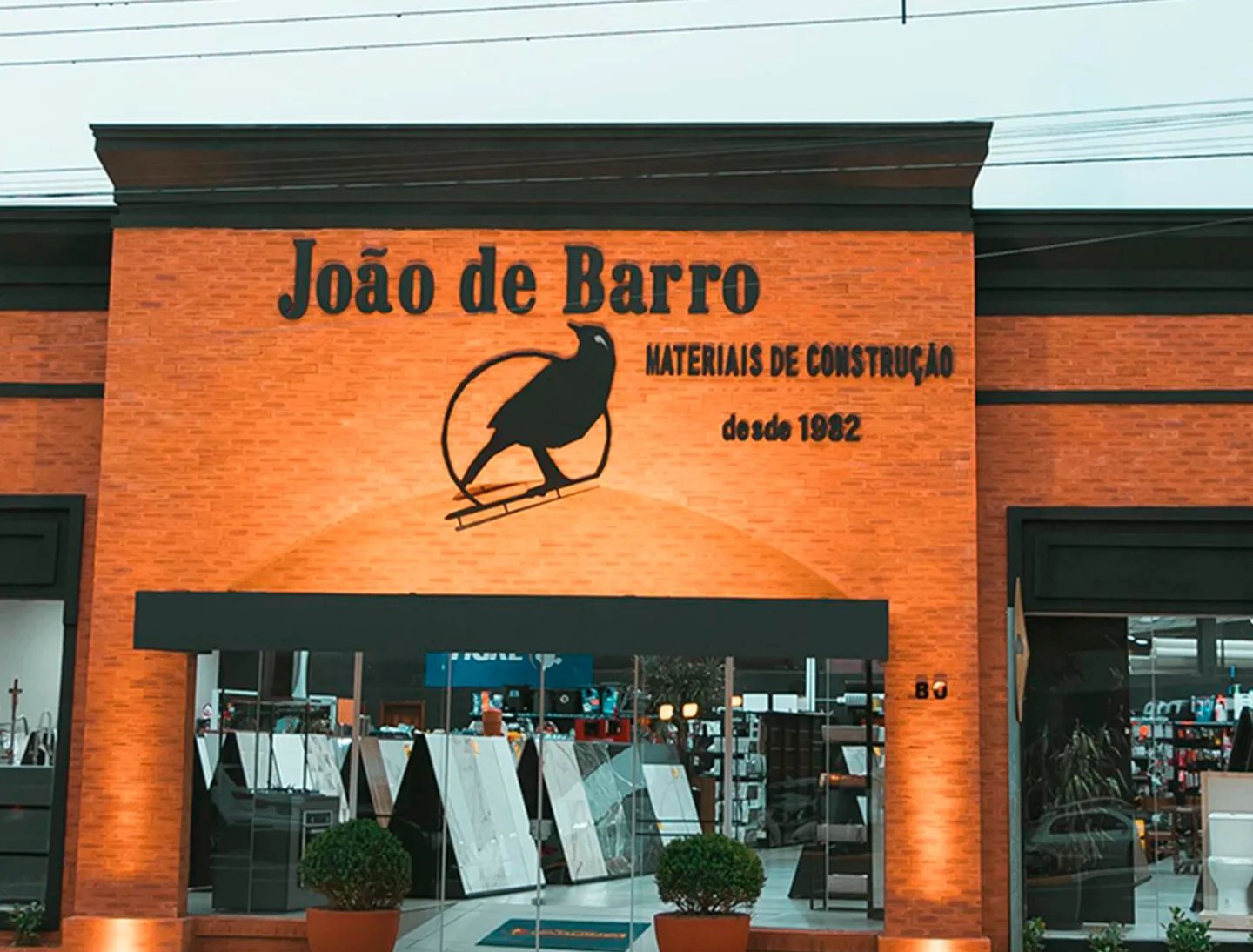 Fachada da loja João de Barro em tijolo aparente, com o letreiro e a calçada de pedras portuguesas
